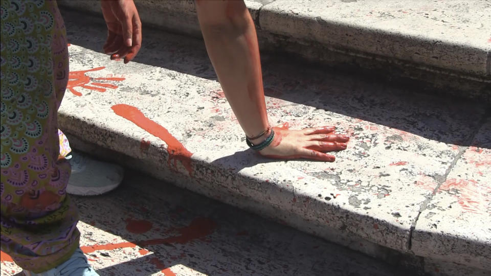 In this frame taken from video activists dump red paint on Rome's Spanish Steps as they protest against violence against women, Wednesday, June 26, 2024. (Lapresse via AP)