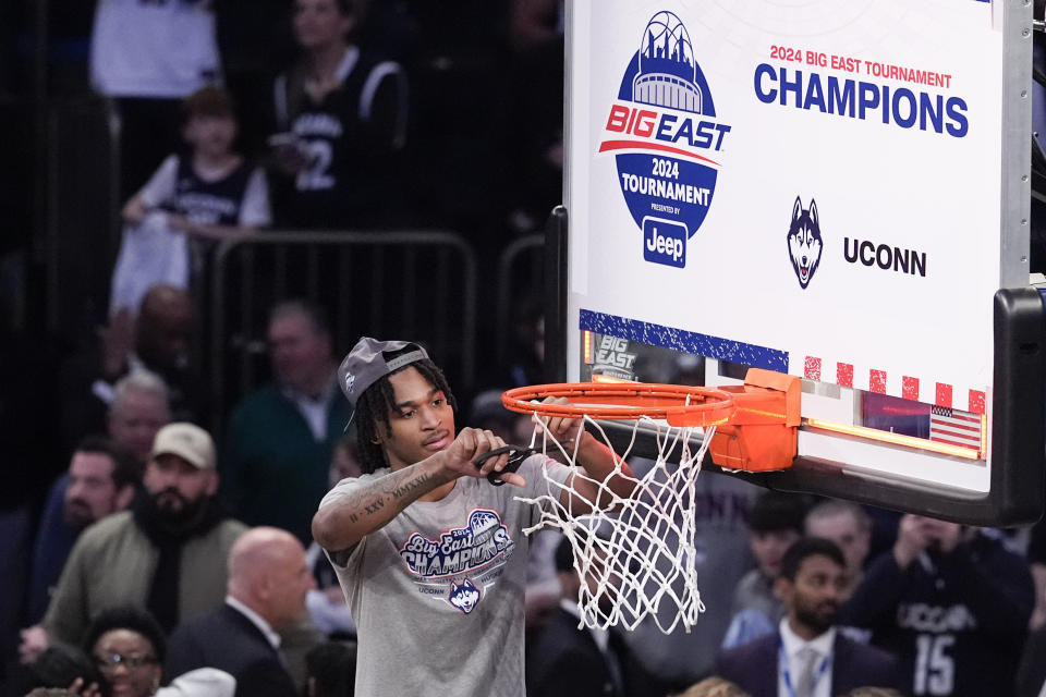 CORRECTS ID TO STEPHON CASTLE INSTEAD OF TRISTEN NEWTON - UConn guard Stephon Castle cuts the net after UConn defeated Marquette in an NCAA college basketball game for the championship of the Big East men's tournament Saturday, March 16, 2024, in New York. (AP Photo/Mary Altaffer)