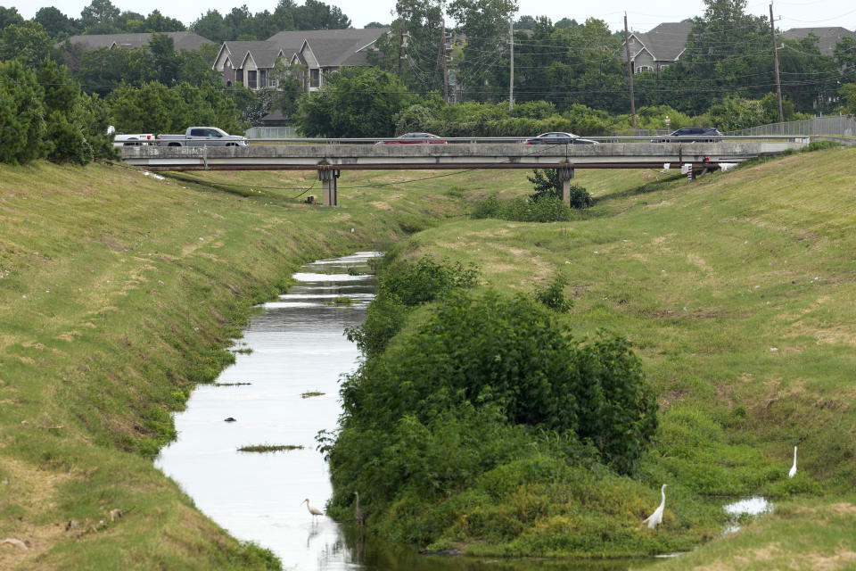 A bridge crosses a creek Tuesday, June 18, 2024, in Houston. Two men who were seen on surveillance footage with a 12-year-old girl hours before her body was found in a Houston creek earlier this week were arrested Thursday, June 20, 2024, in her death, police said. (Melissa Phillip/Houston Chronicle via AP)