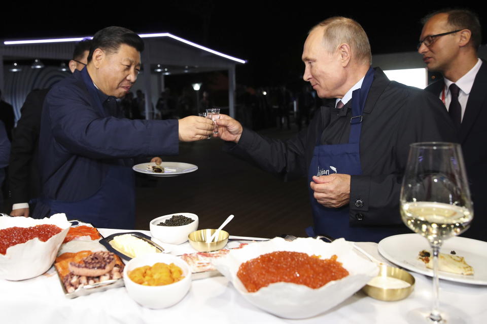 Chinese President Xi Jinping, left, and Russian President Vladimir Putin toast as they taste a food, during a visit to an exhibition during the Eastern Economic Forum in Vladivostok, Russia, Tuesday, Sept. 11, 2018. (Sergei Bobylev/TASS News Agency Pool Photo via AP)