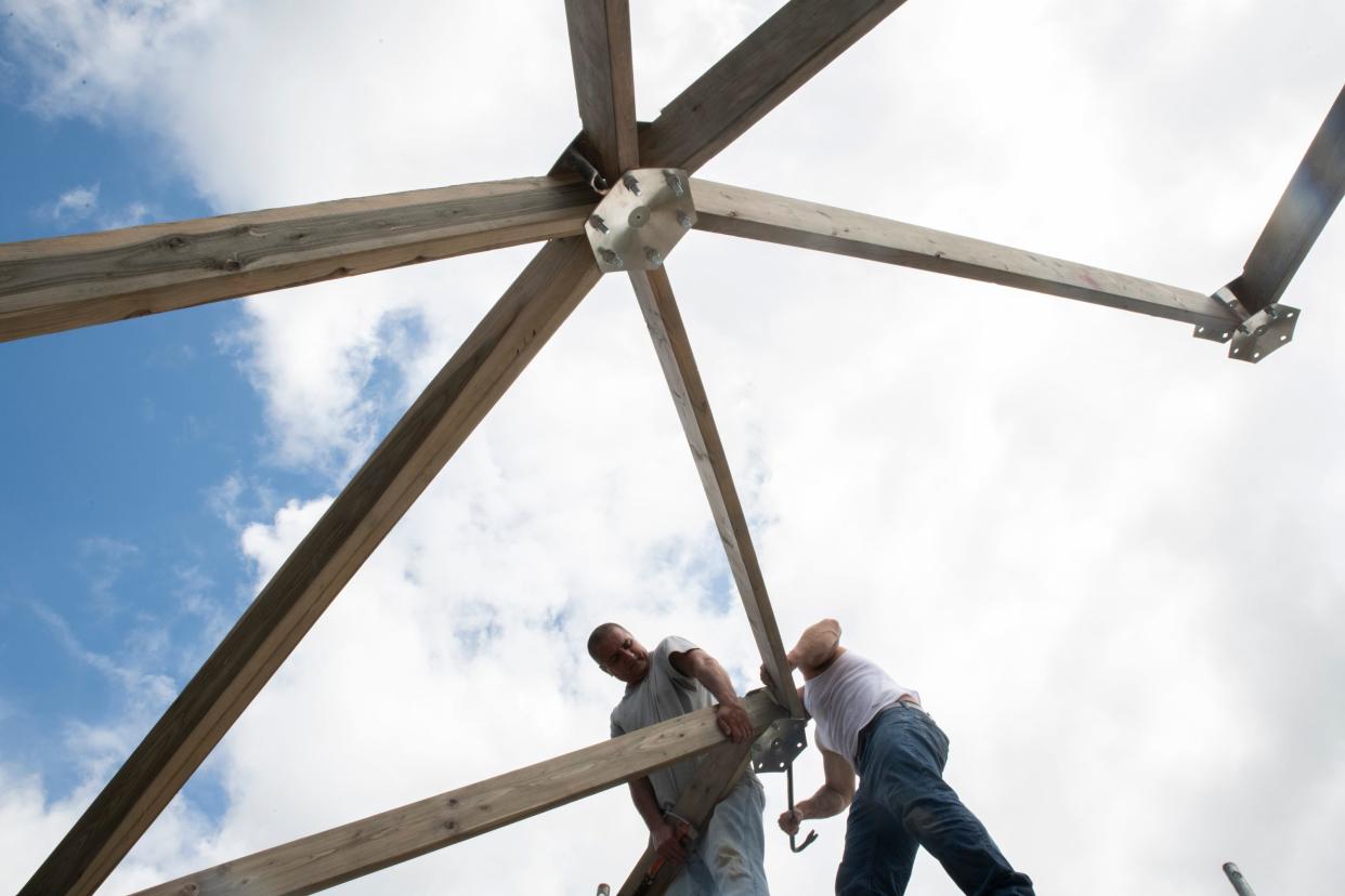 Volunteers from the South Bend Community Re-Entry Center work on the framing of a new Geo Dome that will become a year round learning lab and growing center at Unity Gardens in South Bend.