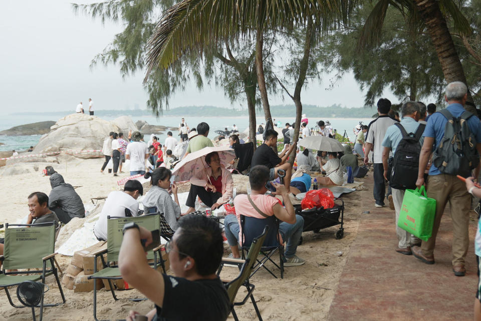 Spectators on a beach near the Wenchang Space Launch site on Thursday.  (Fred Dufour/NBC News)