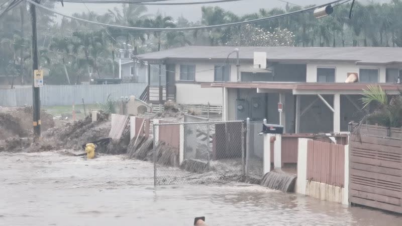 Social media video grab shows floodwaters streaming down a street in Hauula, Hawaii