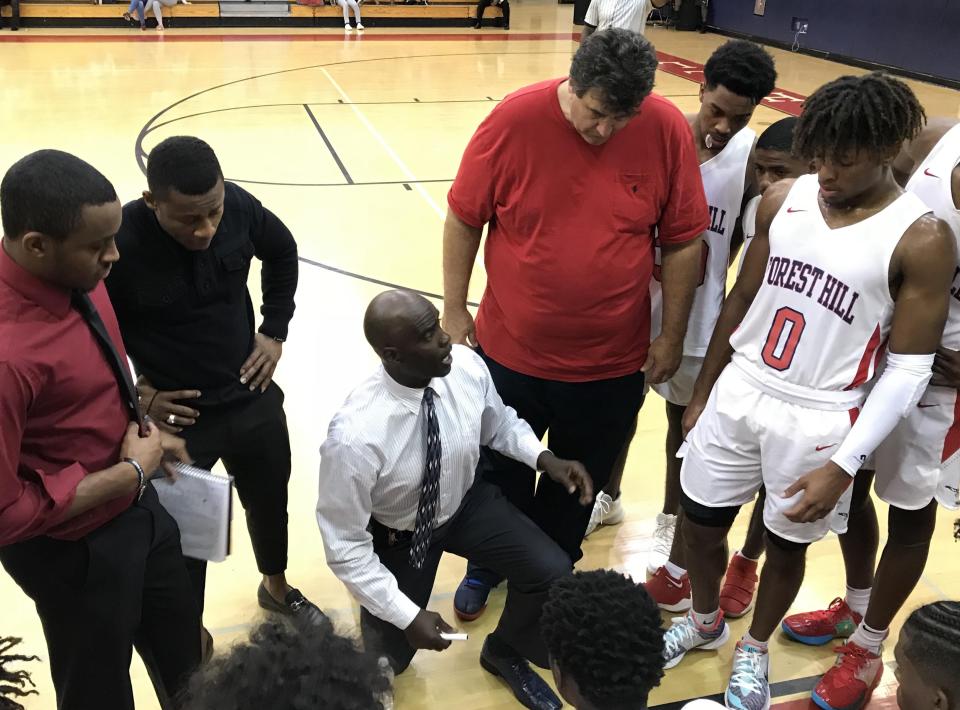 Forest Hill coach Tony Watson (kneeling) has turned around the Forest Hill boys basketball program. Now, he looks to lead the Falcons to a state title.