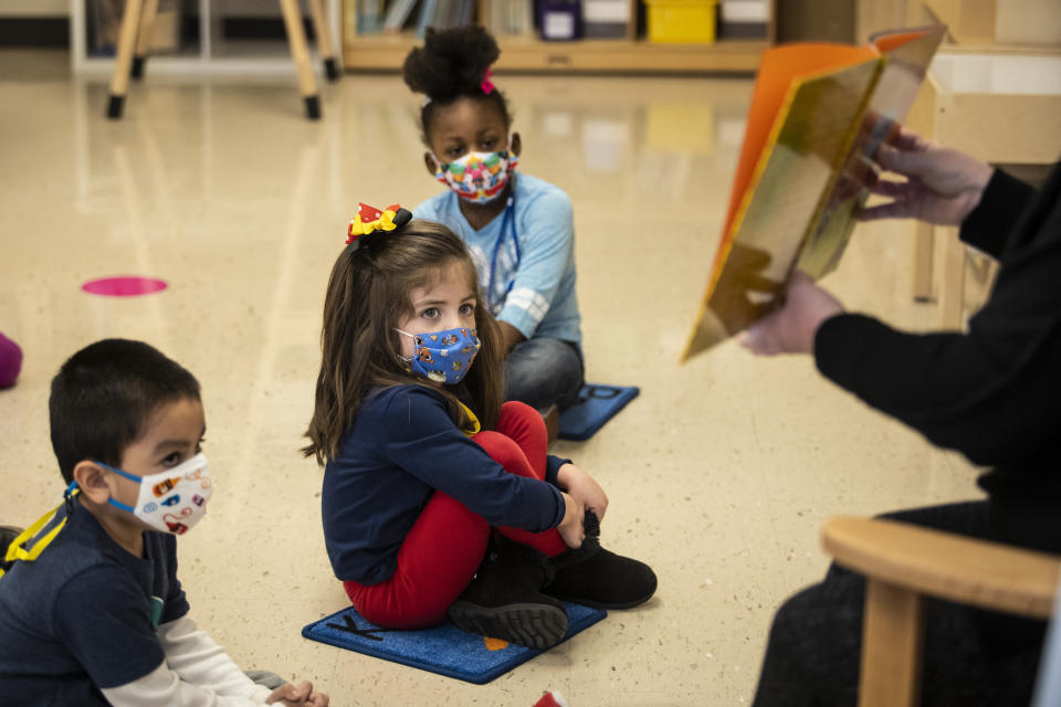 Pre-kindergarten students listen as their teacher reads a story at Dawes Elementary in Chicago, Monday, Jan. 11, 2021. Chicago Public Schools students began their return to the classroom Monday as school doors opened to thousands of pre-kindergarten and some special education students after going remote last March due to the coronavirus pandemic. (Ashlee Rezin Garcia/Chicago Sun-Times via AP, Pool)