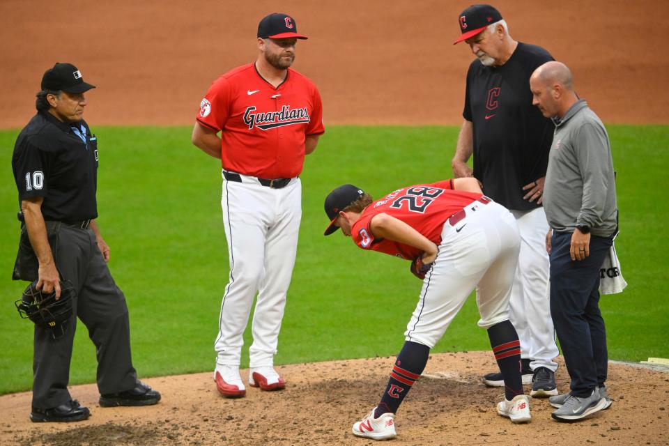 Guardians starting pitcher Tanner Bibee stretches beside manager Stephen Vogt and pitching coach Carl Willis before leaving a game against the Tigers on July 24 in Cleveland.