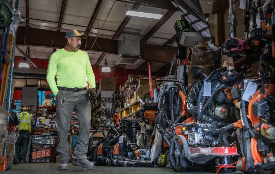 Landscaper Alejandro Martinez walks past repaired equipment at Del Sol Landscape Power Tools in Sacramento in August. Martinez said that he thinks the cost of moving to electric equipment will be expensive for small businesses like his.