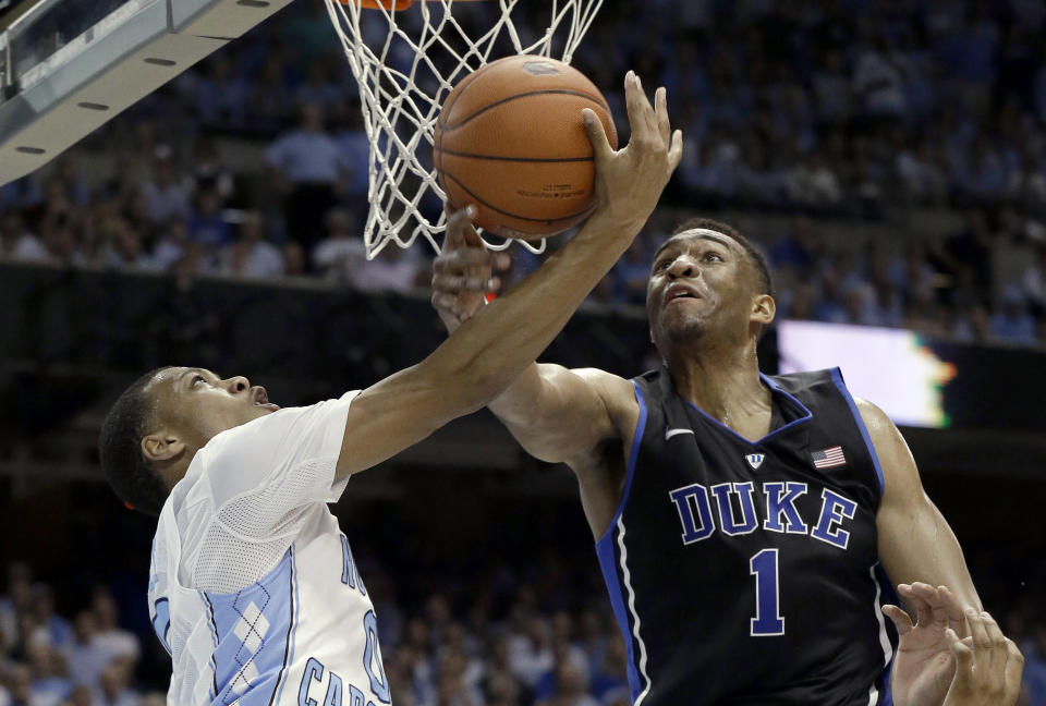 Duke's Jabari Parker (1) blocks North Carolina's Nate Britt during the first half of an NCAA college basketball game in Chapel Hill, N.C., Thursday, Feb. 20, 2014. (AP Photo/Gerry Broome)