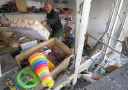 A toy shop owner looks for undamaged goods at his shop damaged by shelling by Azerbaijan's artillery at a market in Stepanakert, the separatist region of Nagorno-Karabakh, Saturday, Oct. 31, 2020. Nagorno-Karabakh authorities said Azerbaijani military targeted a street market in Stepanakert and residential areas of Shushi on Saturday in violation of a mutual pledge not to target residential areas made after talks in Geneva. (AP Photo)