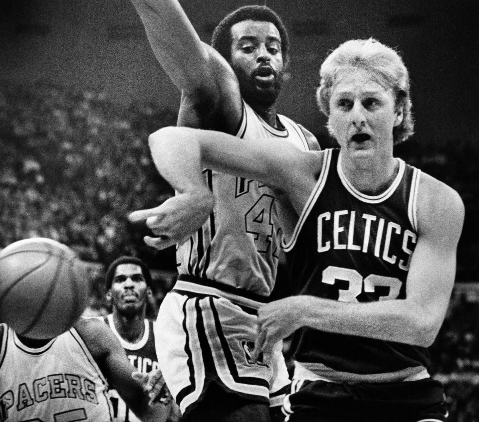 Boston Celtics forward Larry Bird, right, passes off after driving the baseline on Indiana Pacers forward Mike Bantom, left, during first period action of their NBA game in Indianapolis, March 6, 1981. (AP Photo/AB)