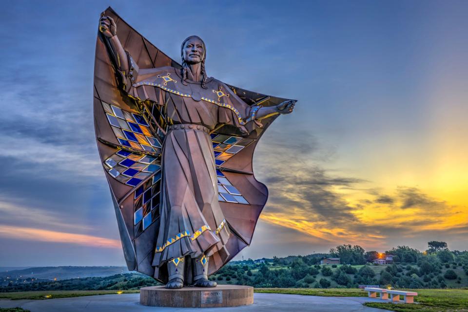 The 50-foot high stainless steel statue “Dignity of Sky and Earth” overlooks the Missouri River on a bluff near Chamberlain. Artist laureate Dale Lamphere designed the statue, which depicts an Indigenous woman in Plains-style dress receiving a star quilt.