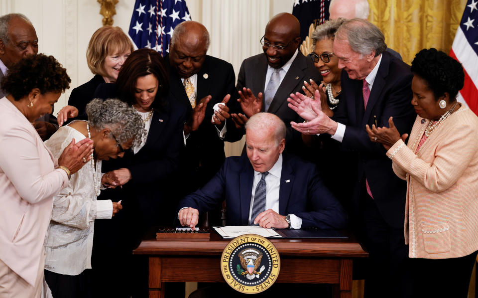 President Joe Biden is applauded as he reaches for a pen to sign the Juneteenth National Independence Day Act into law at the White House on June 17, 2021. (Carlos Barria / Reuters)