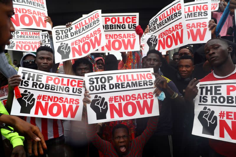 FILE PHOTO: Demonstrators carry banners during a protest over alleged police brutality, in Lagos