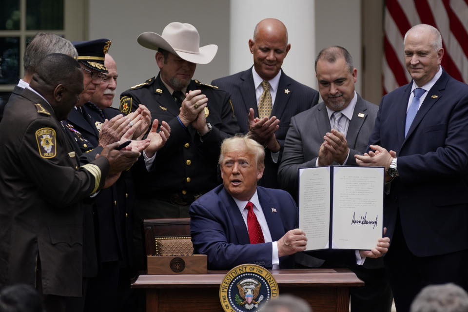 Law enforcement officials applaud after President Donald Trump signed an executive order on police reform, in the Rose Garden of the White House, Tuesday, June 16, 2020, in Washington. (AP Photo/Evan Vucci)