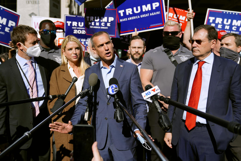 President Donald Trump's campaign advisor Corey Lewandowski, center, speaks outside the Pennsylvania Convention Center where votes are being counted, Thursday, Nov. 5, 2020, in Philadelphia, following Tuesday's election. At left is former Florida Attorney General Pam Bondi. (AP Photo/Matt Slocum)