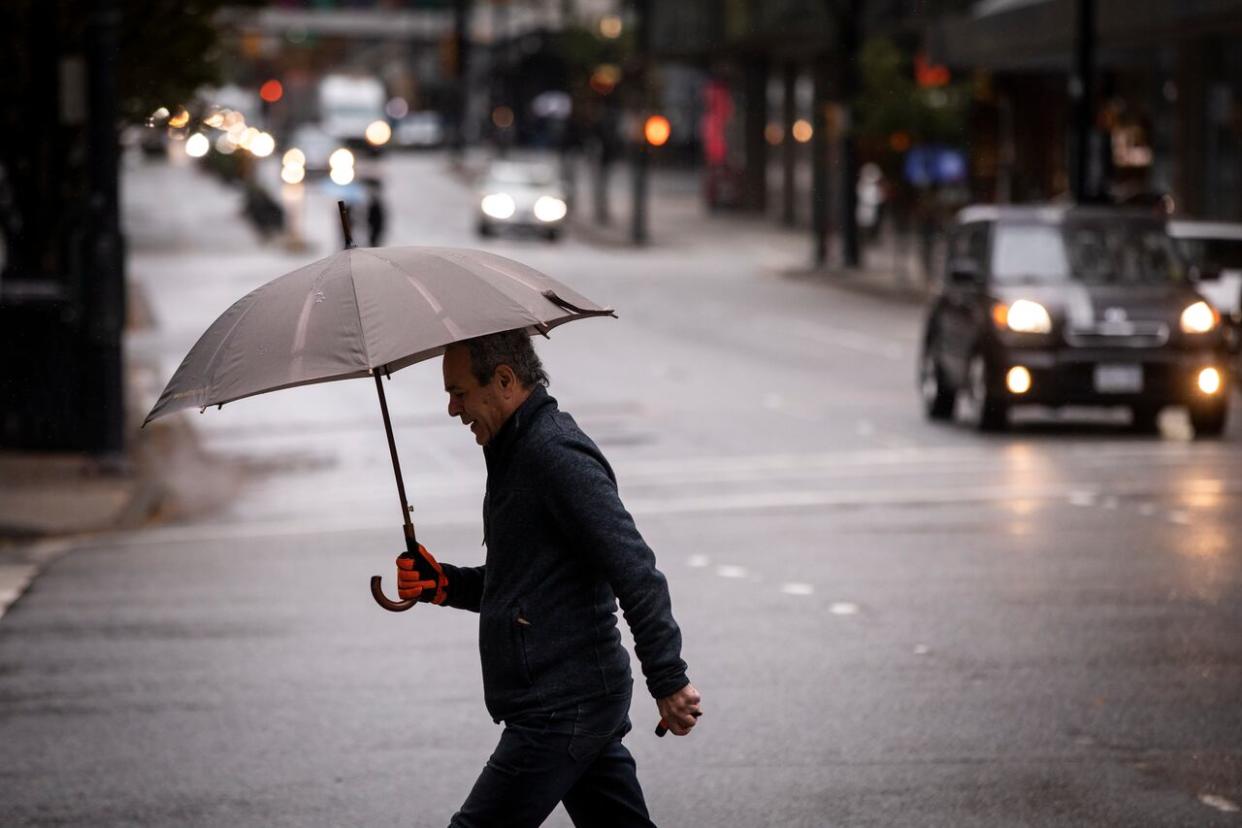 People are pictured during a period of wet weather in Downtown Vancouver in November 2022. Environment Canada warns B.C.'s south coast will be hit with heavy rainfall on Monday. (Ben Nelms/CBC - image credit)