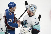 Colorado Avalanche center Nathan MacKinnon, left, congratulates former teammate Seattle Kraken goaltender Philipp Grubauer after the third period of Game 7 of an NHL first-round playoff series Sunday, April 30, 2023, in Denver. The Kraken won 2-1 to advance to the next round. (AP Photo/David Zalubowski)