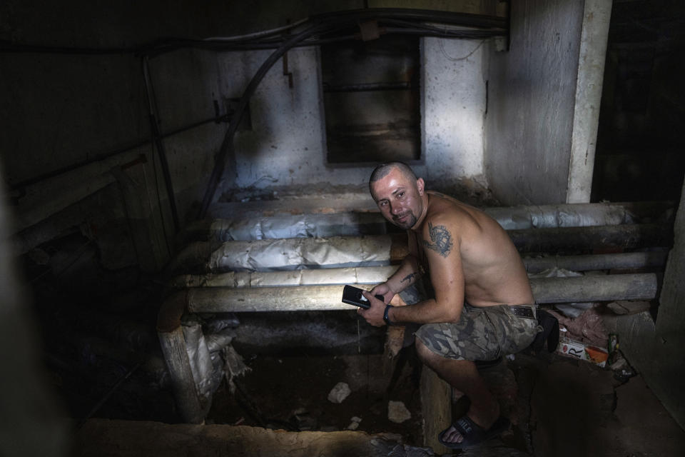 Viktor Lazar, 37, collects water from a pumping system in the basement of his apartment house in Saltivka district after Russian attacks in Kharkiv, Ukraine, Tuesday, July 5, 2022. (AP Photo/Evgeniy Maloletka)