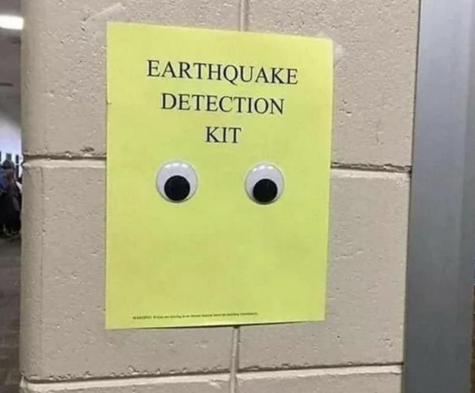 Paper with "EARTHQUAKE DETECTION KIT" text and two googly eyes attached