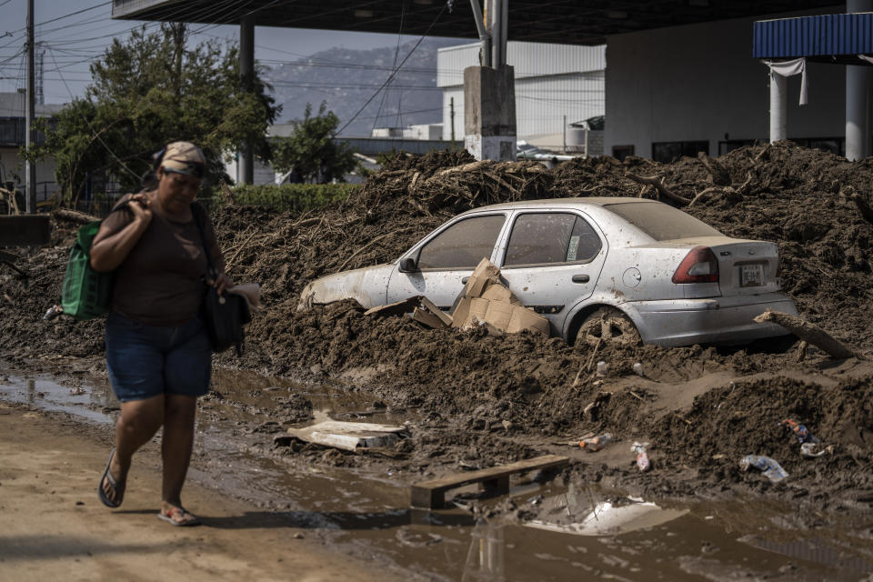 A woman walks through a damaged zone in the aftermath of Hurricane Otis in Acapulco, Mexico, Sunday, Oct. 29, 2023. Mexican authorities have raised the toll to 48 dead from the Category 5 storm that struck the country's southern Pacific coast. (AP Photo/Felix Marquez)