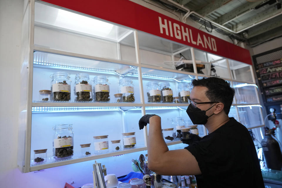 Staff of the Highland Cafe select portions of marijuana for a customer in Bangkok, Thailand, Thursday, June 9, 2022. Measures to legalize cannabis became effective Thursday, paving the way for medical and personal use of all parts of cannabis plants, including flowers and seeds.(AP Photo/Sakchai Lalit)