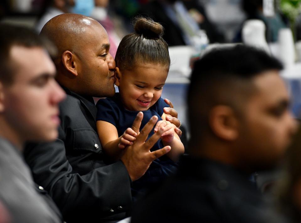 Worcester Police Officer James Soto, Sr., sits with his daughter, Virginia, 3, during the Martin Luther King, Jr. Community Breakfast at Quinsigamond Community College on Monday.