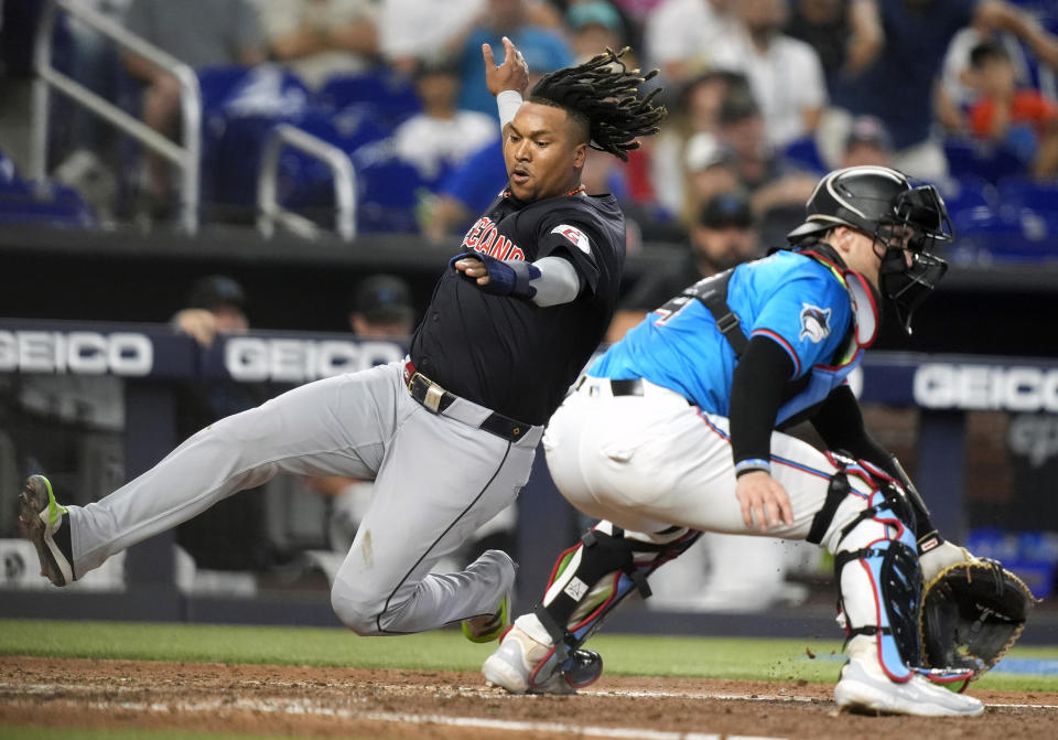 Cleveland Guardians' Jose Ramirez, left, scores past Miami Marlins catcher Nick Fortes, right, on a single hit by David Fry during the sixth inning of a baseball game Sunday, June 9, 2024, in Miami. (AP Photo/Lynne Sladky)