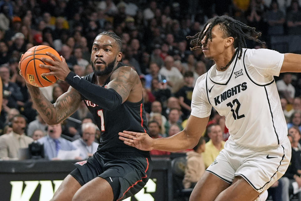 Houston guard Jamal Shead (1) drives past Central Florida guard DeMarr Langford Jr. (12) during the first half of an NCAA college basketball game, Wednesday, March 6, 2024, in Orlando, Fla. (AP Photo/John Raoux)