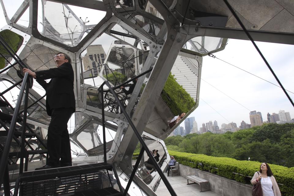 Visitors look at a structure by Tomas Saraceno called "Cloud City" during a media preview on the rooftop of the Metropolitan Museum of Art in New York, Monday, May 14, 2012. The maker of Cloud City, Argentine artist Tomas Saraceno, wants to provoke the feeling of being in a cloud floating in the middle of several realities. (AP Photo/Seth Wenig)
