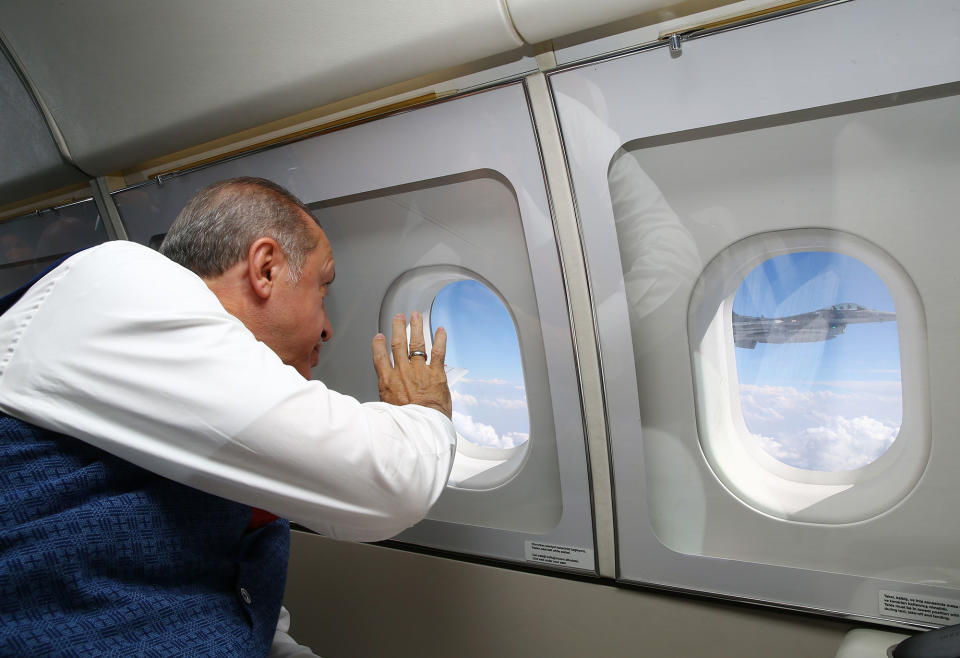 President Erdogan waves from inside his airplane