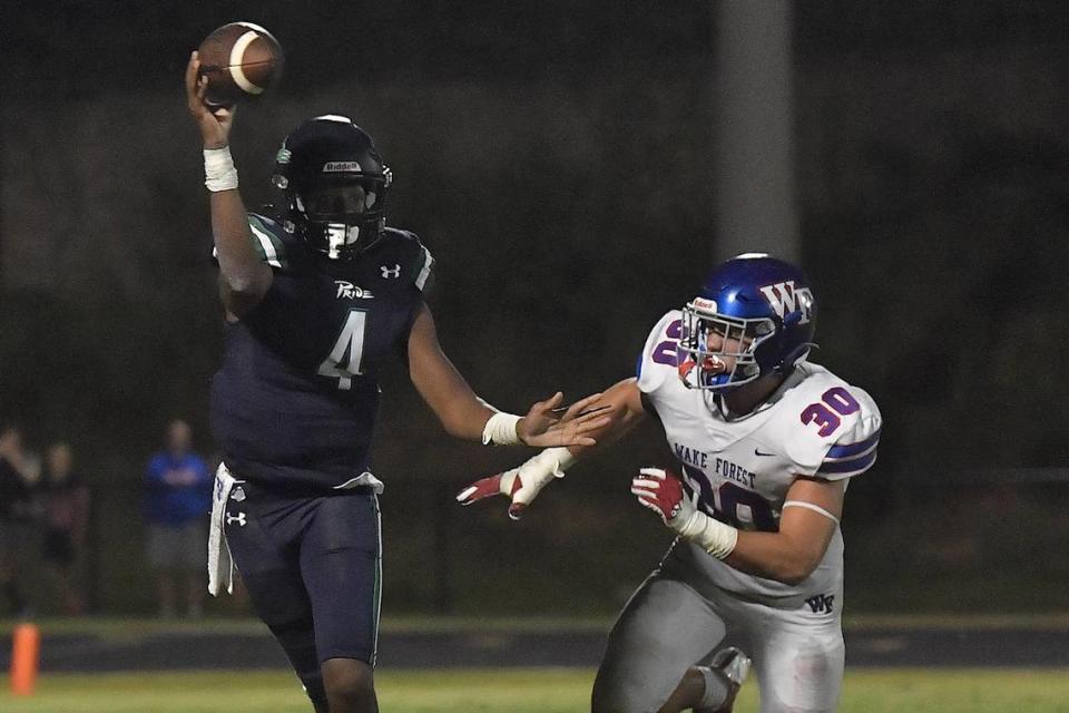 Leesville Road’s Deiondre Goldston (4) passes against pressure from Wake Forest’s Zane Williams in the second half. The Wake Forest Cougars and the Leesville Road Pride met in a football game in Raleigh, N.C. on September 15, 2023.