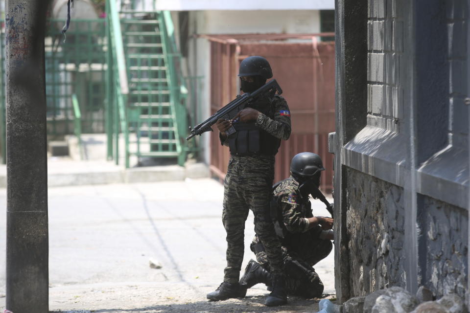 Police take cover during an anti-gang operation next to the National Palace in Port-au-Prince, Haiti, Monday, April 8, 2024. (AP Photo/Odelyn Joseph)