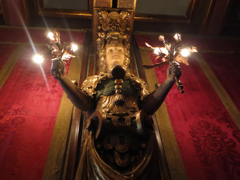 This Aug. 30, 2013 photo shows an ornately carved figure holding light fixtures in the plush movie theater at the Hearst Castle, the 165-room estate owned by newspaper publisher William Randolph Hearst in San Simeon, Calif. Visitors can tour the estate which he called "La Cuesta Encantada" ("The Enchanted Hill"), that overlooks the Pacific Ocean. (AP Photo/Jim MacMillan)