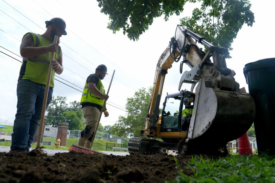 Workers continue road work along Paxton Avenue in the Oakley neighborhood of Cincinnati on July 19.