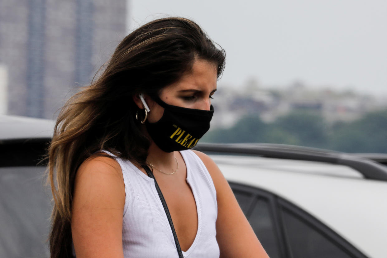 A woman wears a protective face mask outside at a shopping plaza in Edgewater, New Jersey, July 8, 2020. REUTERS/Mike Segar