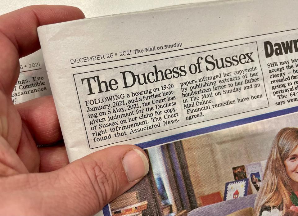 A man holds a copy of the Mail on Sunday with a printed a statement on page three acknowledging that the Duchess of Sussex won her copyright claim against the newspaper&#39;s publisher. The statement, under the heading 