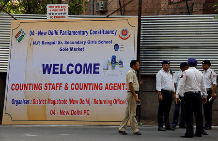 A policeman walks past a hoarding outside a vote counting centre in New Delhi, India, May 22, 2019. REUTERS/Anushree Fadnavis