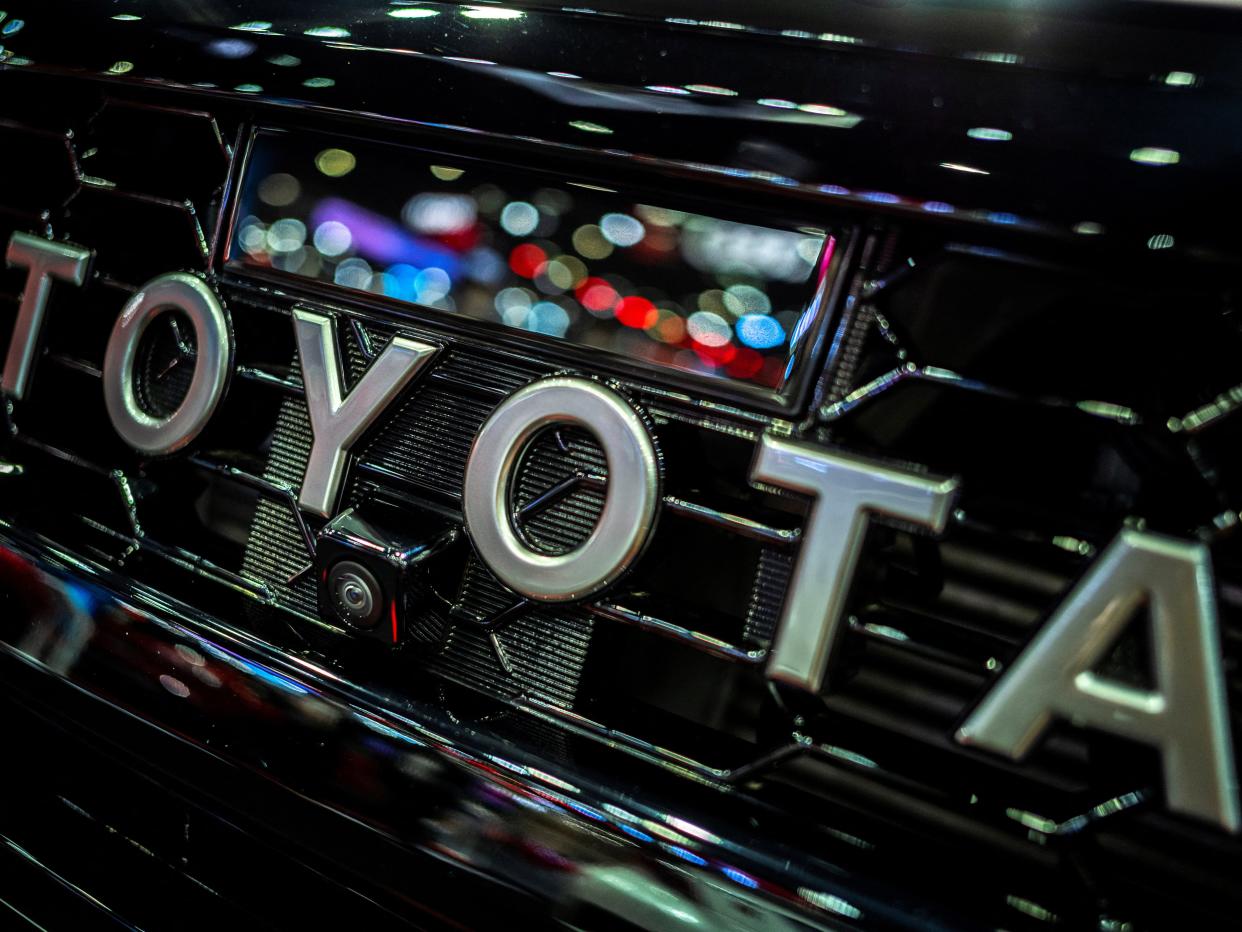 The Toyota logo in silver font on the front of a vehicle.