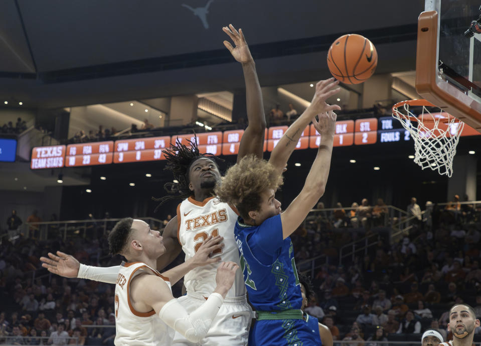 Texas A&M Corpus Christi forward Owen Dease, front right, goes up to shoot against Texas forward Ze'Rik Onyema, center, and guard Chendall Weaver, left, during the first half of an NCAA college basketball game, Friday, Dec. 22, 2023, in Austin, Texas. (AP Photo/Michael Thomas)