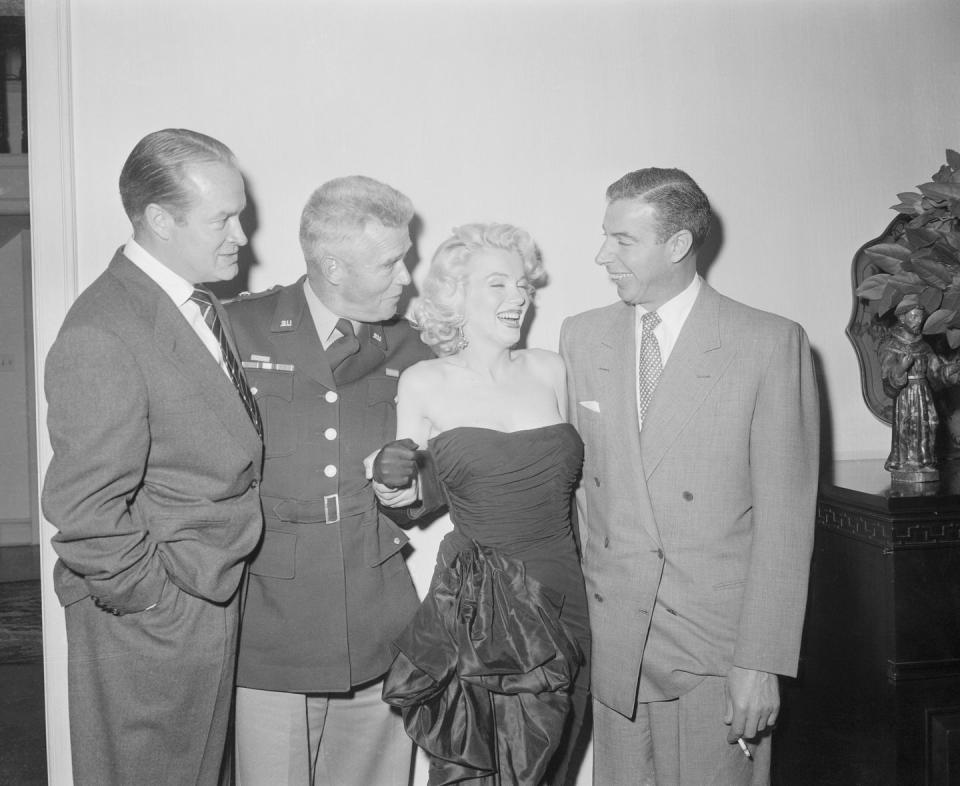 <p>Marilyn attended a holiday party at Bob Hope's house. She's surrounded by Hope, General William Dean (who had addressed the U.S. troops in Korea the night before on Hope's show), and baseball great Joe DiMaggio, who will soon become Marilyn's second husband.</p>