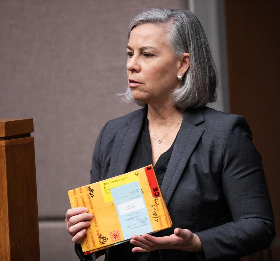 Assistant State Attorney Janine Nixon holds DNA swabs collected from multiple people as evidence for the FDLE lab during the Christopher Alan Smith Trial Wednesday October 11, 2023. Smith is charged with second degree murder and aggravated battery with a deadly weapon. He's accused of killing Amy Scott. The trial was being held in Judge Peter Bringham’s courtroom at the Marion County Judicial Center in Ocala, Fla. [Doug Engle/Ocala Star Banner]2023