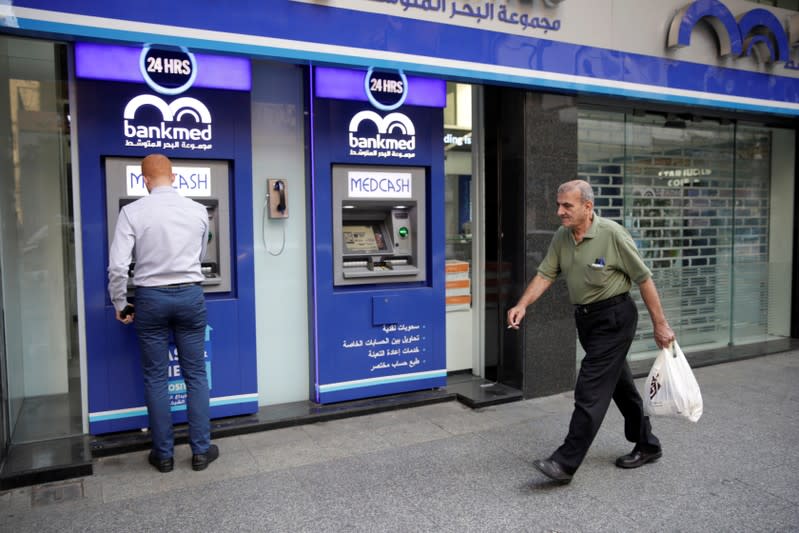 A man walks past a closed bank office in Beirut