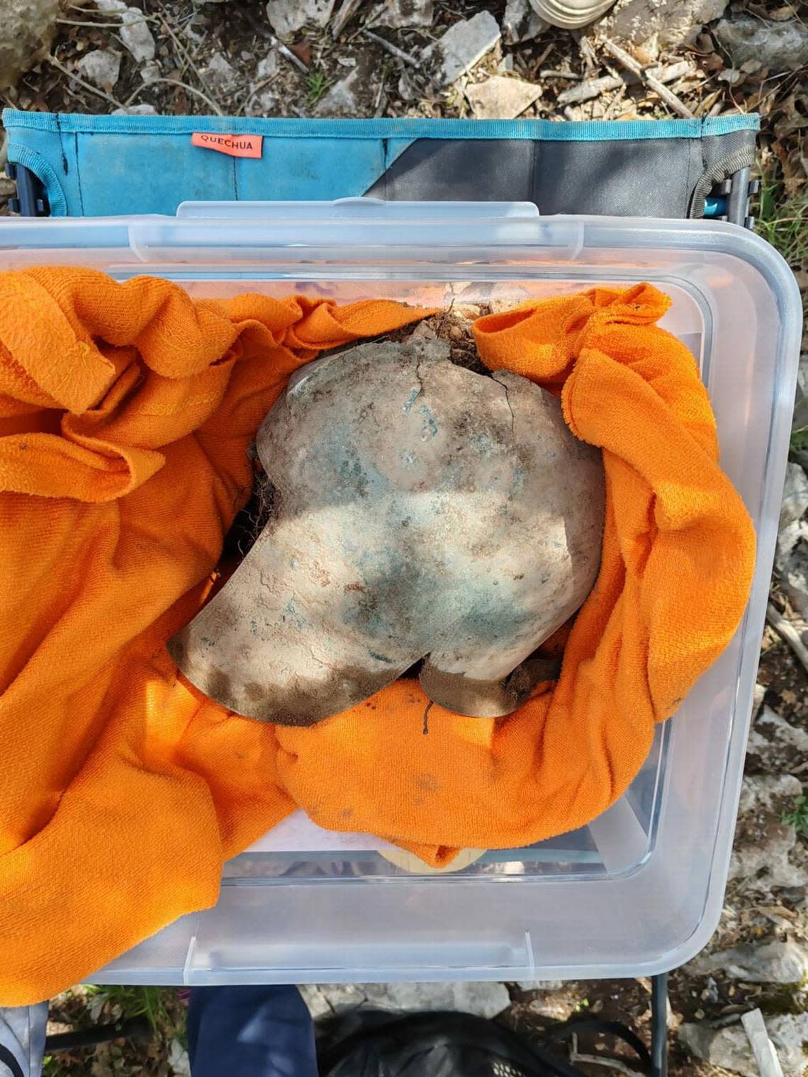 The 2,500-year-old helmet sits in a container after being excavated.