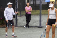 Lan Yao-Gallop watches as coach Mark Gellard gestures towards Magda Linette as she prepares to serve on a practice court at the Charleston Open tennis tournament in Charleston, S.C., Monday, April 3, 2023. Yao-Gallop, a 43-year-old from China who now lives in Edmonton, is participating in the women’s professional tennis tour’s Coach Inclusion Program. (AP Photo/Mic Smith)