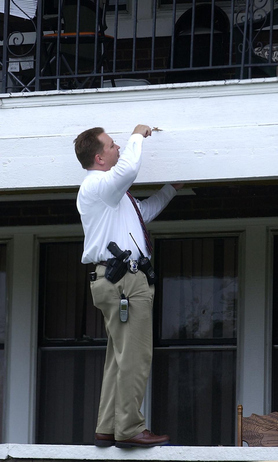 Cincinnati Police Detective John Horn checks for a bullet slug at the scene of a fatal shooting in 2005 that led to the arrest of suspect Quincy Jones. Afterward, Jones worked as a police informant for Horn and helped authorities investigate at least a dozen homicides in exchange for a plea deal.