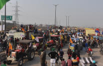 NEW DELHI, INDIA - JANUARY 26: Farmers with his tractor arrive for enter in the capital for Tractor Republic Day parade rally farmers' ongoing agitation over the new farm laws at Bhalswa Ring Road on January 26, 2021 in New Delhi, India. Major scenes of chaos and mayhem at Delhi borders as groups of farmers allegedly broke barricades and police check posts and entered the national capital before permitted timings. Police used tear gas at Delhi's Mukarba Chowk to bring the groups under control. Clashes were also reported at ITO, Akshardham. Several rounds of talks between the government and protesting farmers have failed to resolve the impasse over the three farm laws. The kisan bodies, which have been protesting in the national capital for almost two months, demanding the repeal of three contentious farm laws have remained firm on their decision to hold a tractor rally on the occasion of Republic Day. (Photo By Sonu Mehta/Hindustan Times via Getty Images)