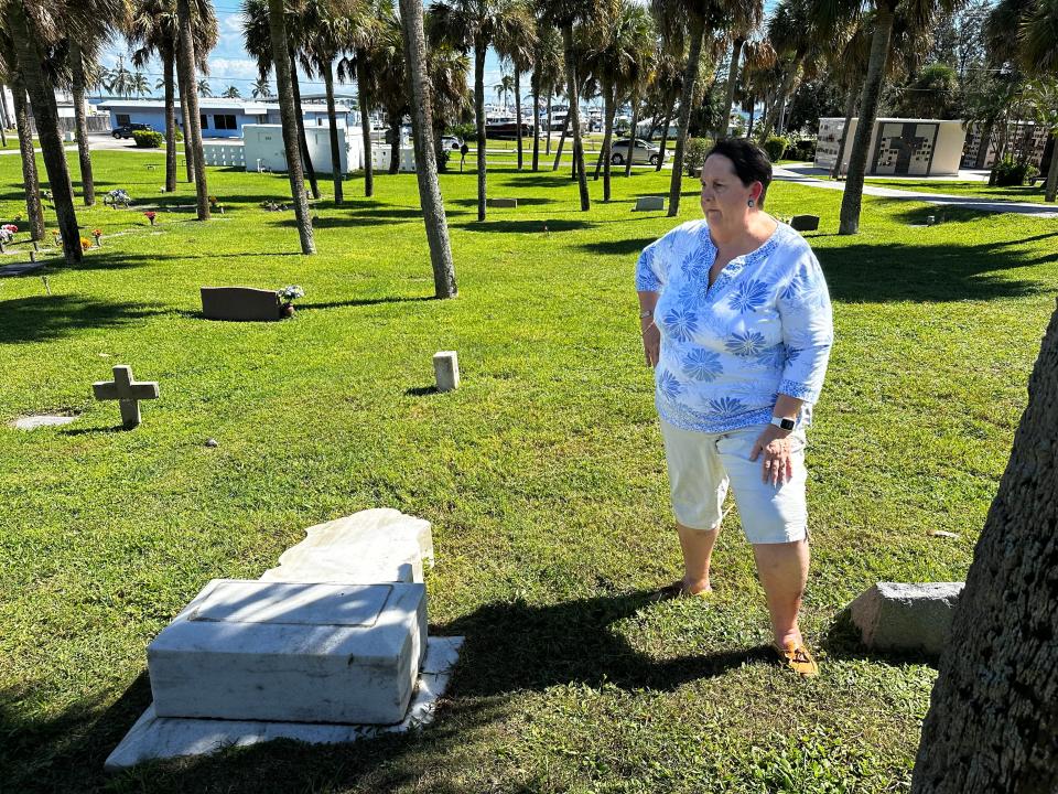 Joyce Fletcher Menard, stands near a reportedly vandalized gravestone at the cemetery of the All Saints Episcopal Church in Jensen Beach on October 18, 2023.