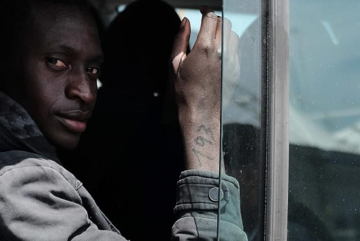 A rescued migrant with a number on his right arm, sits on bus at the Sicilian harbour of Catania, Italy, on April 23, 2015 (AFP Photo/Alberto Pizzoli)