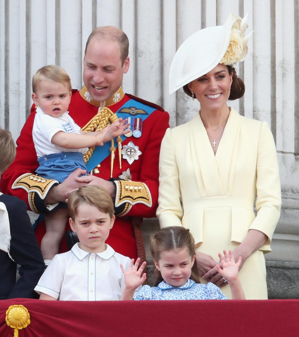Prince William, Duchess Kate of Cambridge, Prince Louis, Prince George and Princess Charlotte on the balcony at Buckingham Palace at the end of the Trooping the Colour parade on June 8, 2019 in London. Kate is wearing a dress by Alexander McQueen in warm yellow with a Philip Treacy hat.