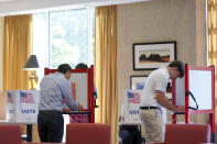 Louisville, Ky., mayoral candidate Craig Greenberg, left, fills out a primary election ballot on Tuesday, May 17, 2022, at the Louisville Presbyterian Theological Seminary in Louisville, Ky. Greenberg, a Democrat, was shot at in February at a campaign office but was not struck, though a bullet grazed a piece of his clothing, police said. (AP Photo/Piper Hudspeth Blackburn)